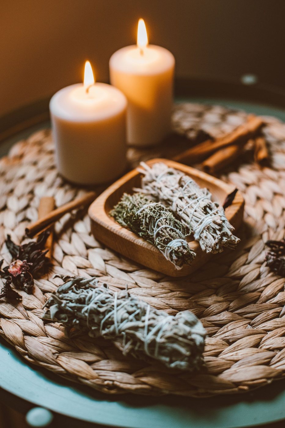 Candles and calming herbs on a woven tray